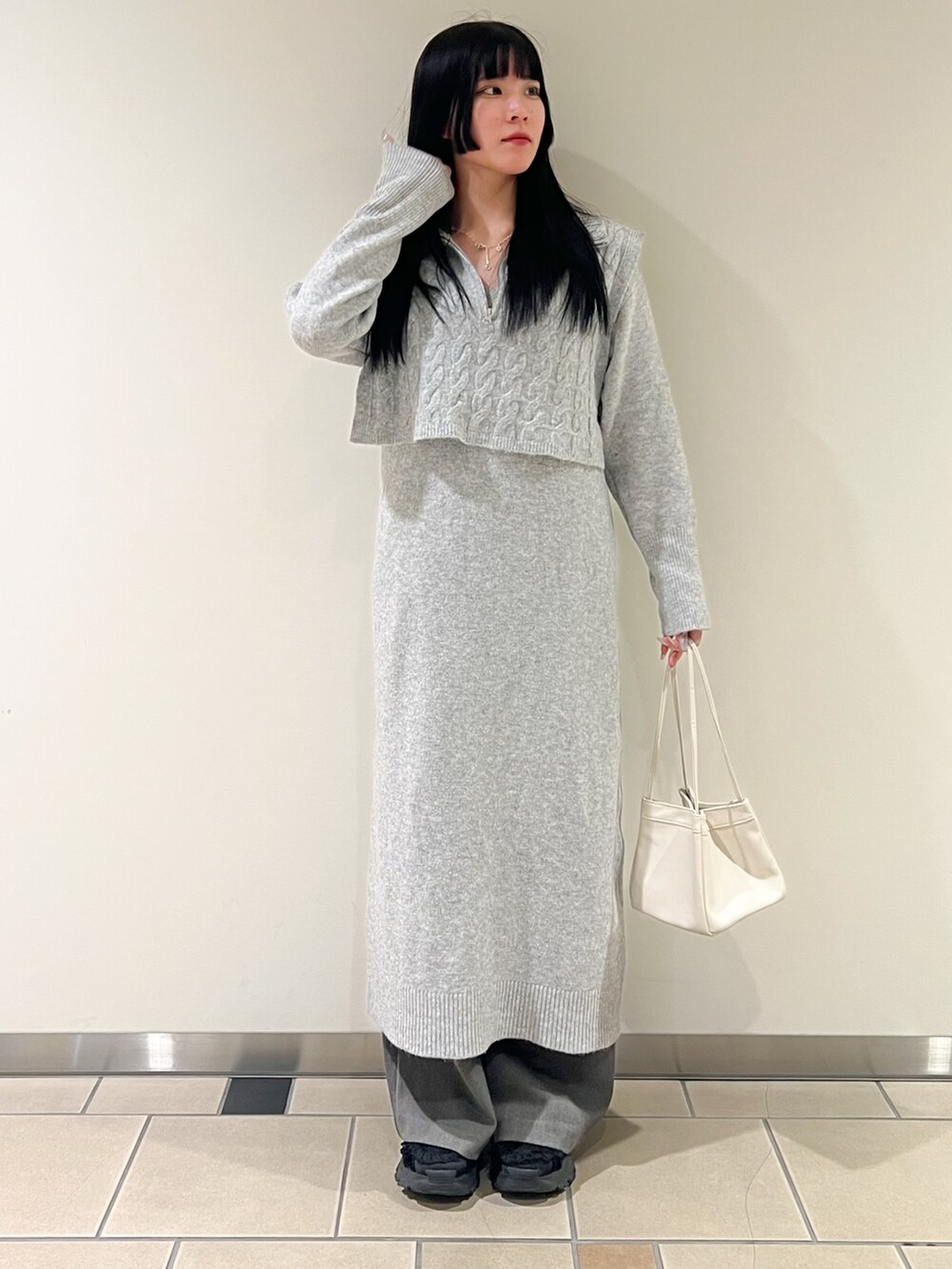 ブラック系のブルゾン、ホワイト系のハンドバッグ、グレー系のその他パンツを着用したレディースの冬コーディネートの2枚目の写真