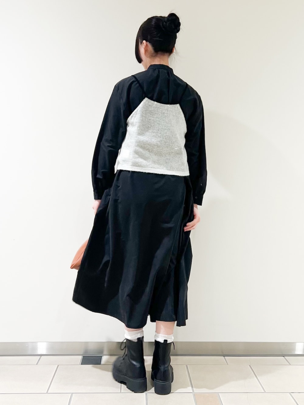 ホワイト系のニット/セーター、ブラック系のワンピース、イエロー系のハンドバッグを着用したレディースの冬コーディネートの2枚目の写真