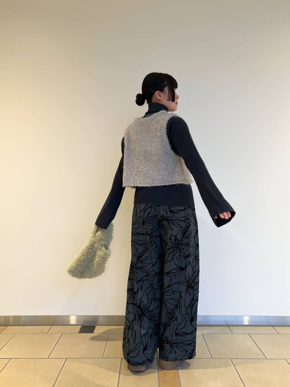 ブルー系のニット/セーター、グリーン系のその他パンツ、グリーン系のハンドバッグを着用したレディースの冬コーディネートの3枚目の写真