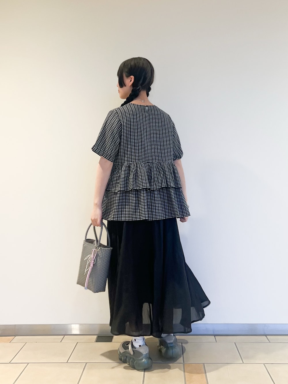 グレー系のトートバッグ、ブラック系のシャツ/ブラウス、ブラック系のスカートを着用したレディースの夏コーディネートの3枚目の写真