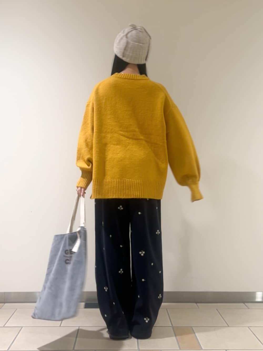 ブルー系のその他パンツ、グレー系のトートバッグ、ベージュ系のニット/セーターを着用したレディースの秋コーディネートの2枚目の写真