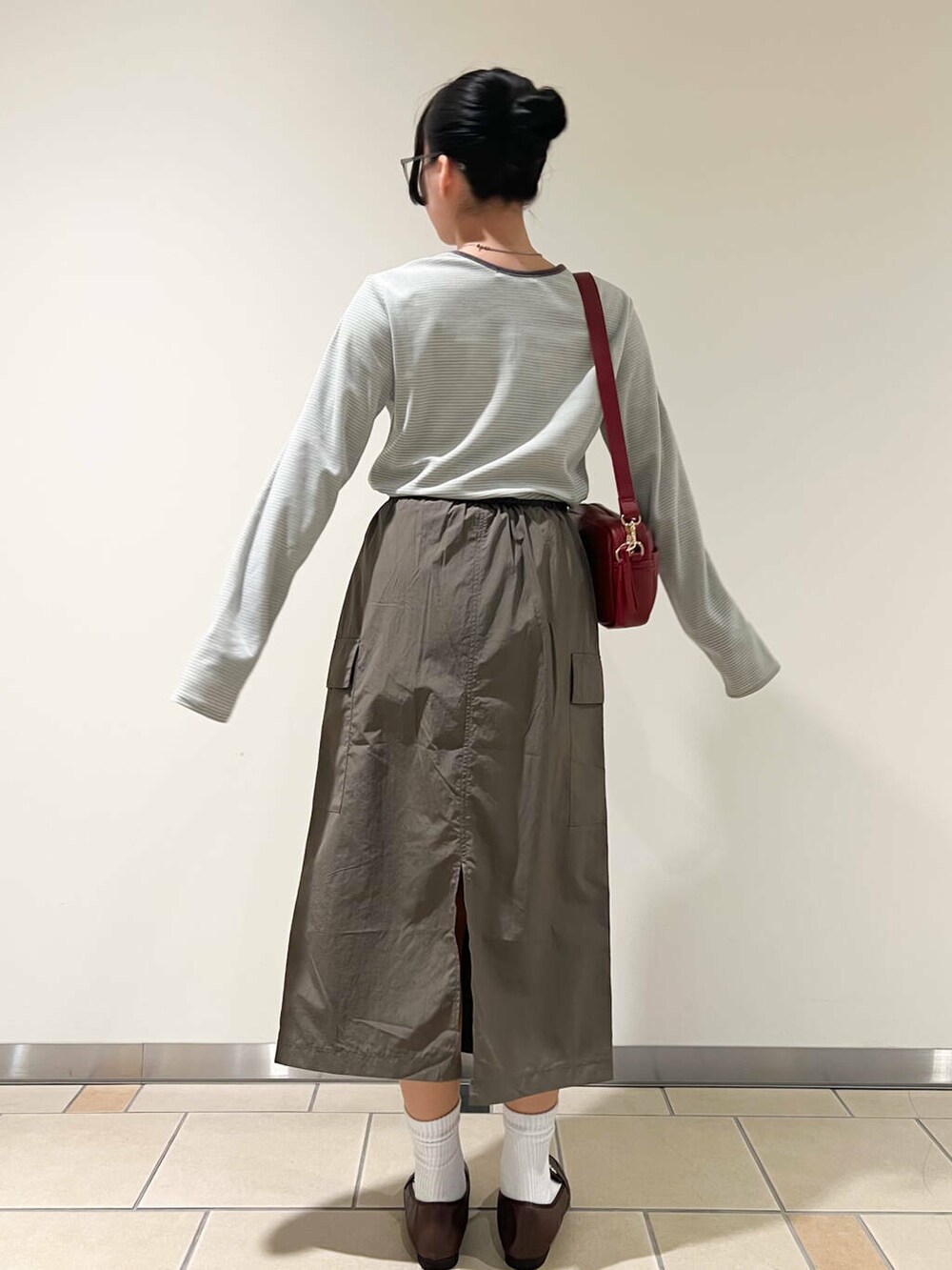 ブラウン系のローファー、レッド系のショルダーバッグ、ベージュ系のTシャツ/カットソーを着用したレディースの春コーディネートの3枚目の写真