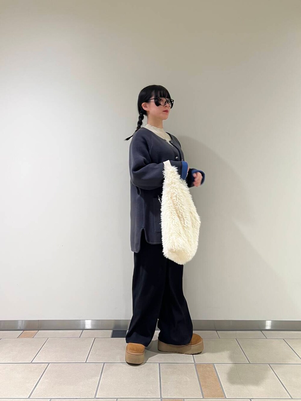 ホワイト系のトートバッグ、グレー系のワンピース、ホワイト系のニット/セーターを着用したレディースの冬コーディネートの2枚目の写真