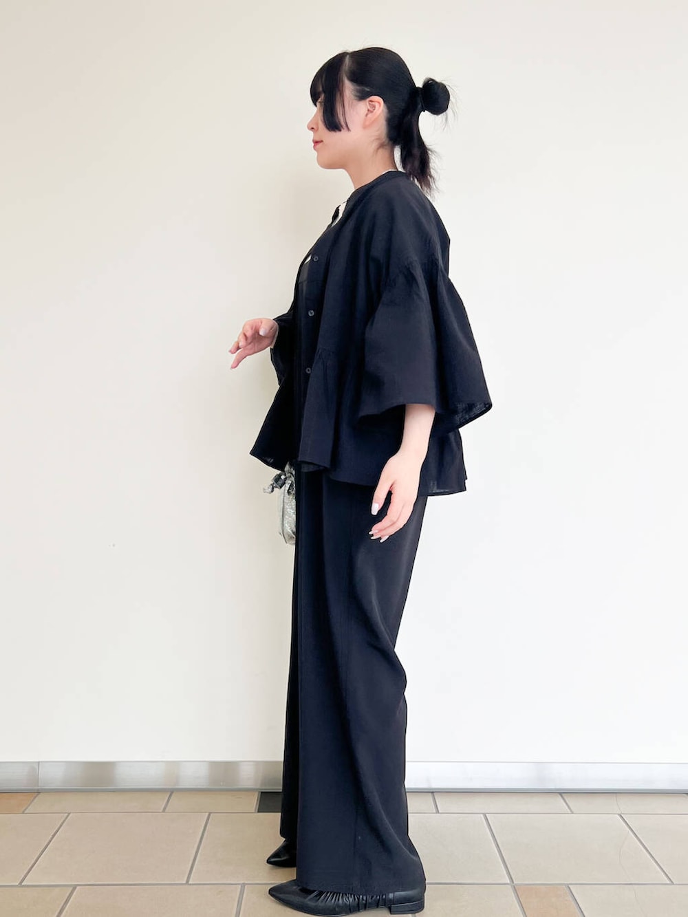 シルバー系のショルダーバッグ、ブラック系のバレエシューズ、ブラック系のシャツ/ブラウスを着用したレディースの春コーディネートの3枚目の写真