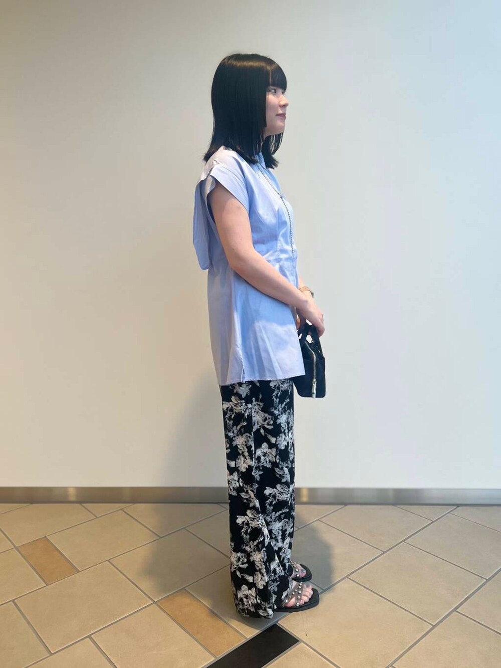 ブラック系のショルダーバッグ、ブラック系のサンダル、パープル系のシャツ/ブラウスを着用したレディースの夏コーディネートの3枚目の写真