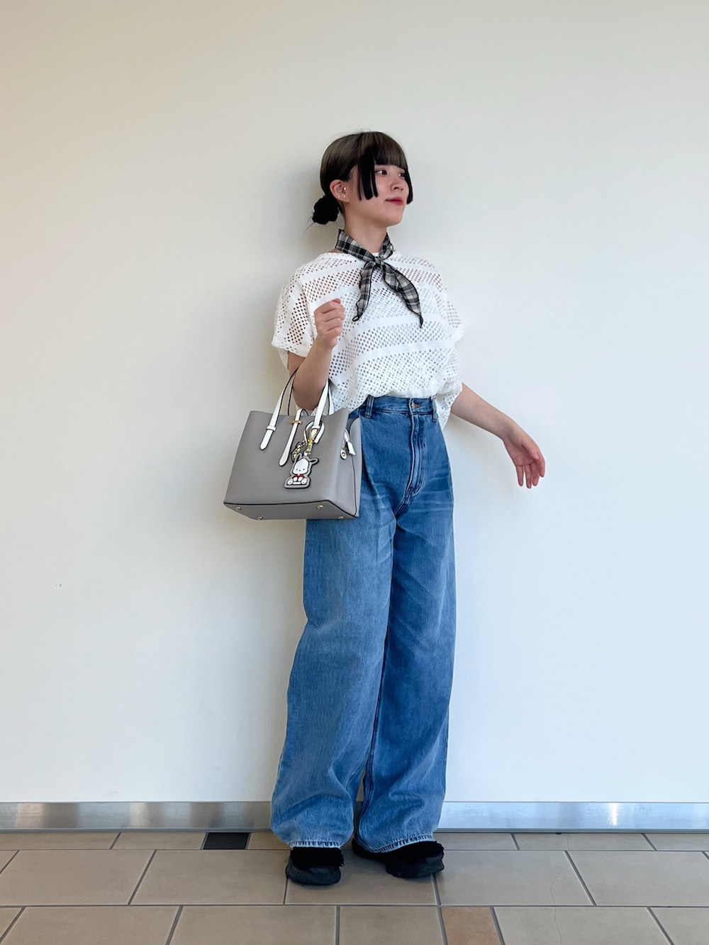 グレー系のハンドバッグ、ブルー系のデニムパンツ、ホワイト系のその他トップスを着用したレディースの夏コーディネートの2枚目の写真