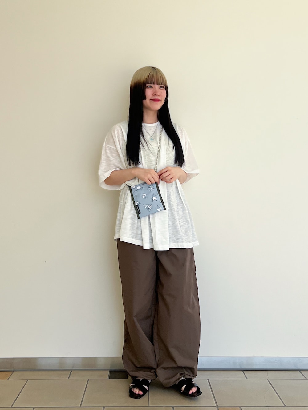 ブラウン系のその他パンツ、グリーン系のニット/セーター、ブラック系のサンダルを着用したレディースの夏コーディネートの2枚目の写真