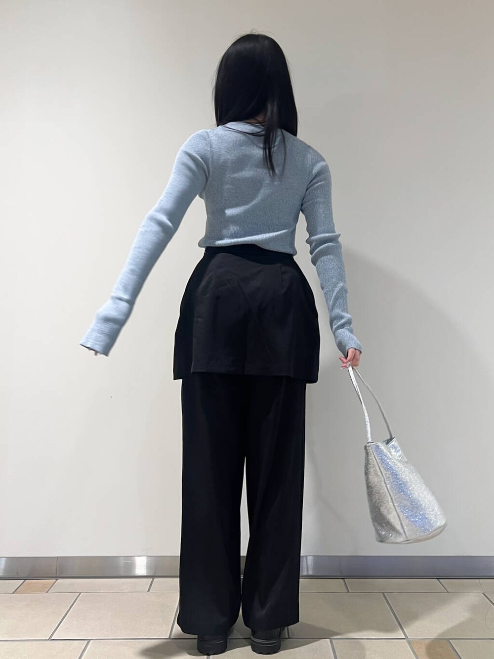 シルバー系のハンドバッグ、ブルー系のニット/セーター、ブラック系のその他パンツを着用したレディースの春コーディネートの3枚目の写真