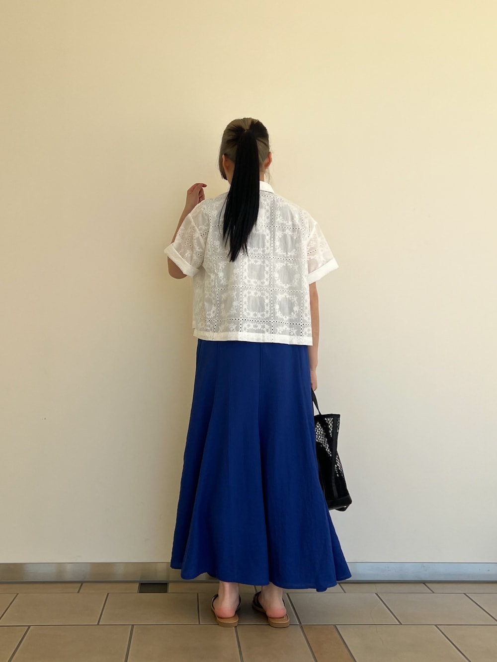 ブルー系のニット/セーター、ホワイト系のシャツ/ブラウス、ブルー系のスカートを着用したレディースの夏コーディネートの2枚目の写真