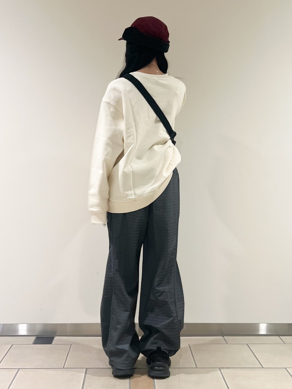 グレー系のその他パンツ、ホワイト系のスウェット、レッド系のキャップを着用したレディースの秋コーディネートの2枚目の写真