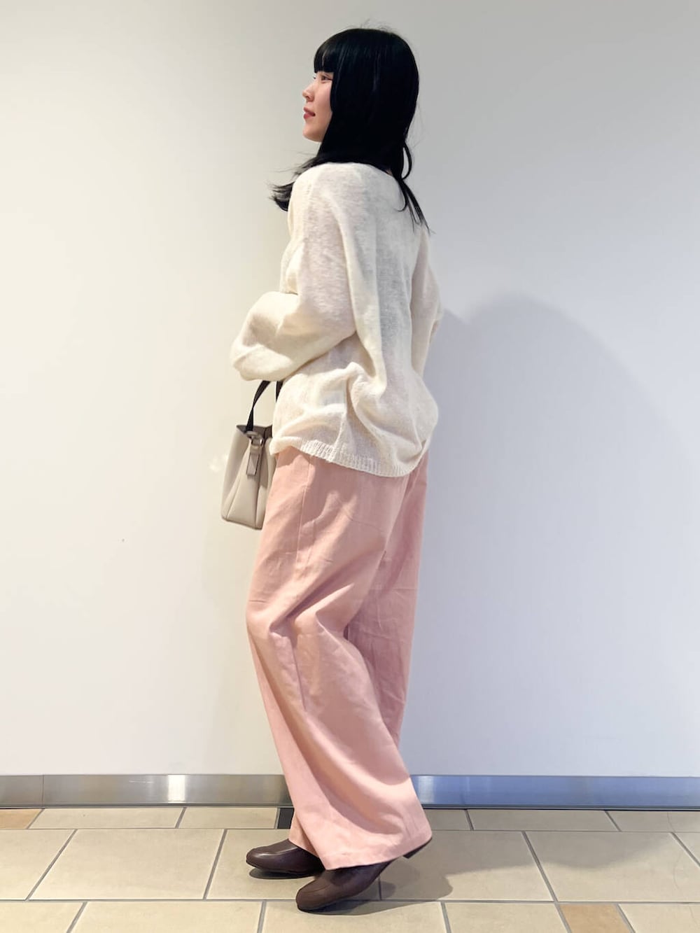 ブラウン系のローファー、ホワイト系のハンドバッグ、ピンク系のその他パンツを着用したレディースの春コーディネートの2枚目の写真