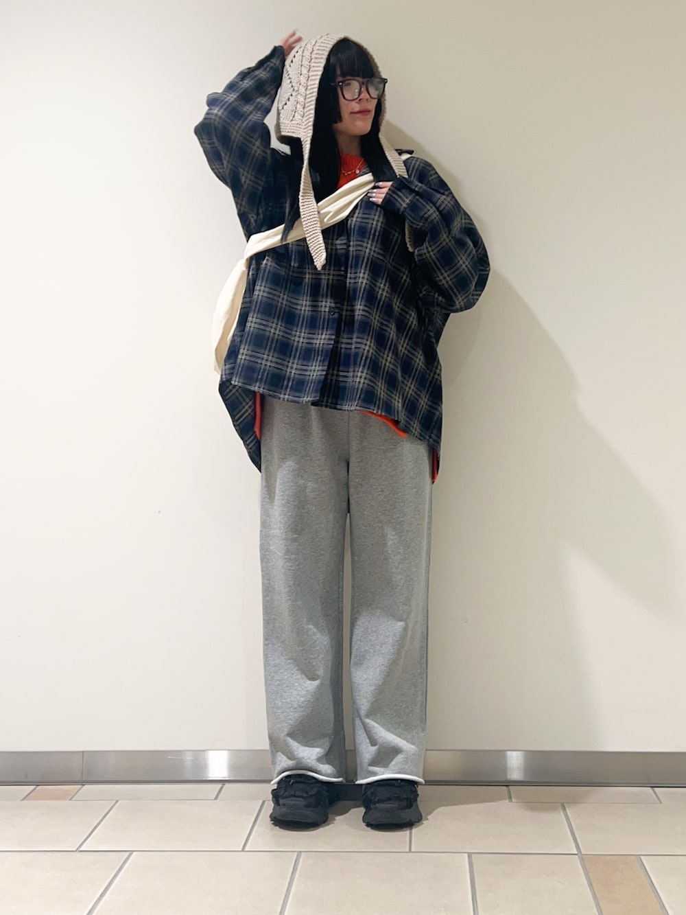 オレンジ系のニット/セーター、ブルー系のシャツ/ブラウス、グレー系のその他パンツを着用したレディースの冬コーディネートの2枚目の写真