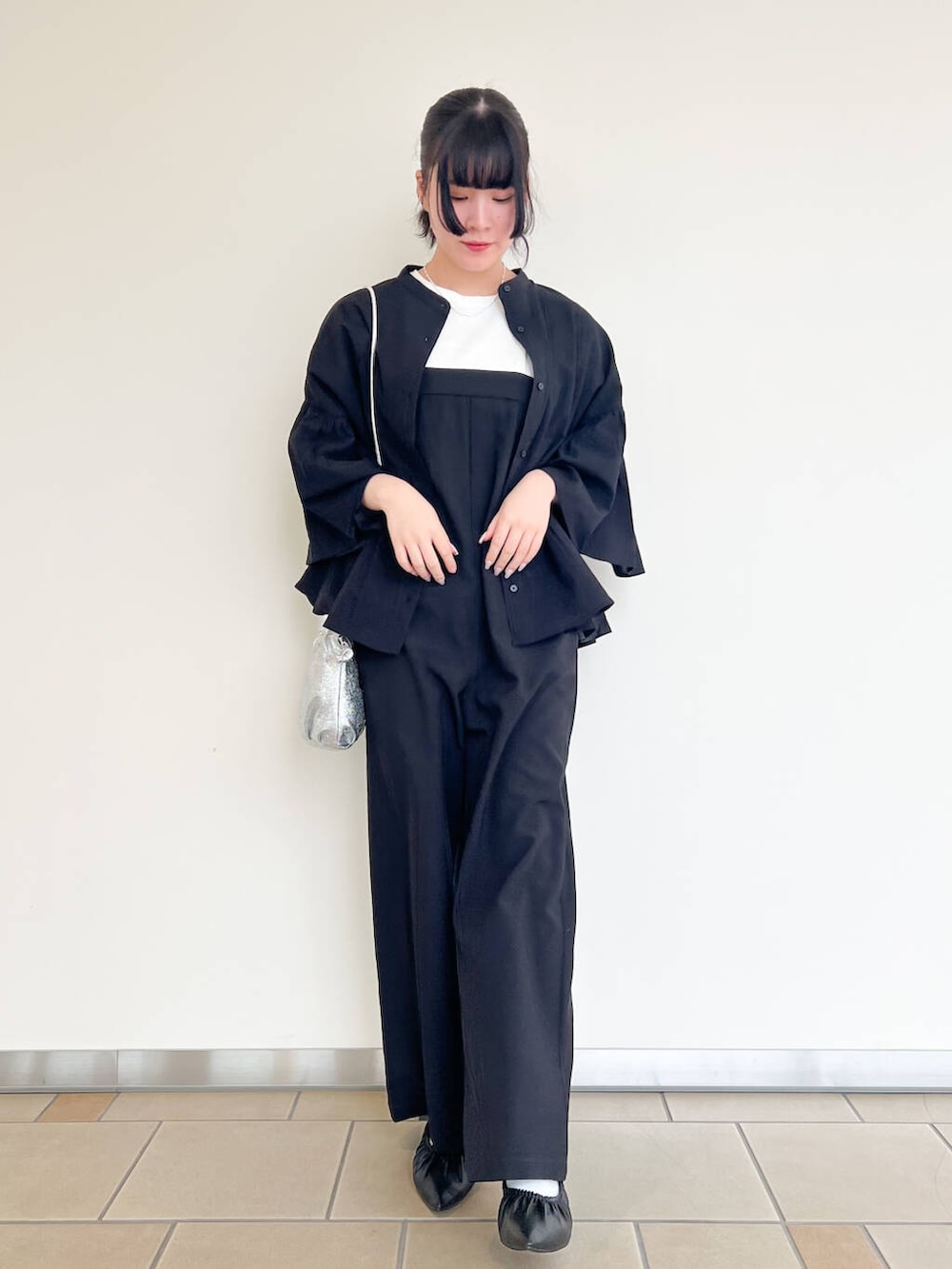 シルバー系のショルダーバッグ、ブラック系のバレエシューズ、ブラック系のシャツ/ブラウスを着用したレディースの春コーディネートの2枚目の写真