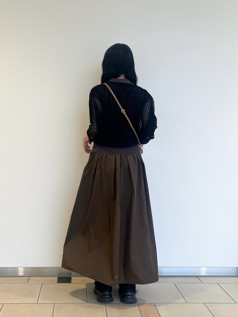 ブラウン系のワンピース、ベージュ系のショルダーバッグ、ブラック系のニット/セーターを着用したレディースの夏コーディネートの2枚目の写真
