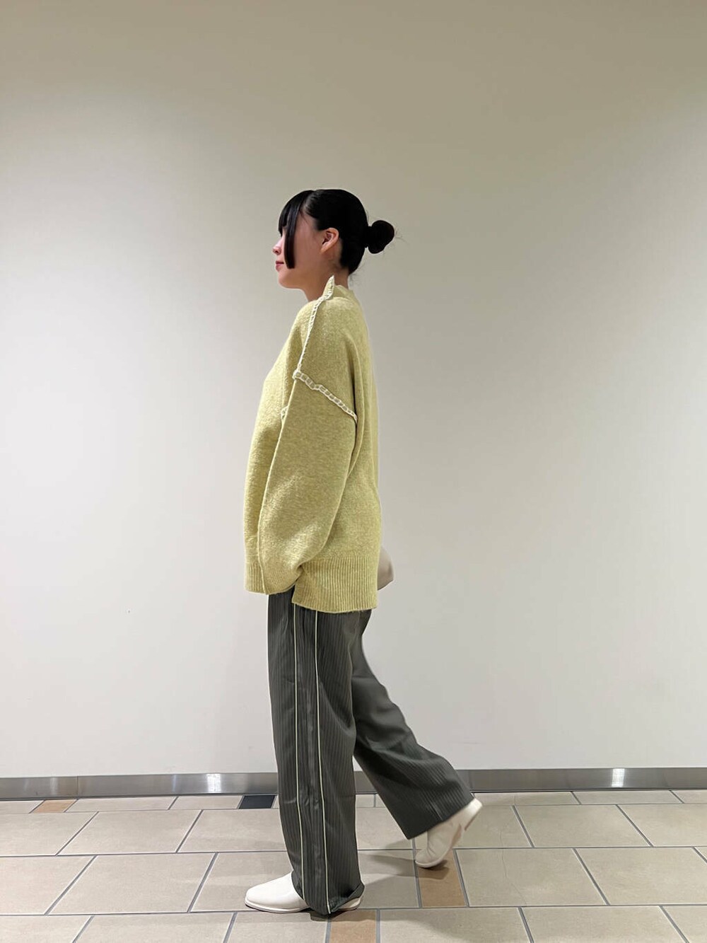 ホワイト系のブーツ、ホワイト系のショルダーバッグ、イエロー系のニット/セーターを着用したレディースの秋コーディネートの3枚目の写真