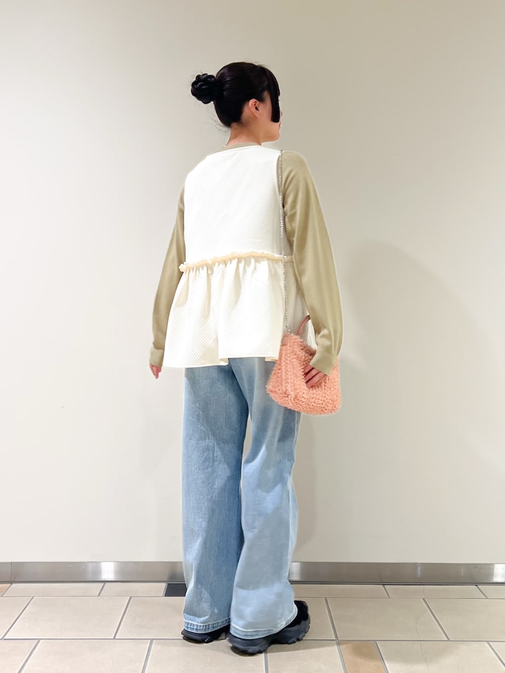 ブルー系のデニムパンツ、ホワイト系のベスト、グリーン系のカーディガン/ボレロを着用したレディースの秋コーディネートの2枚目の写真