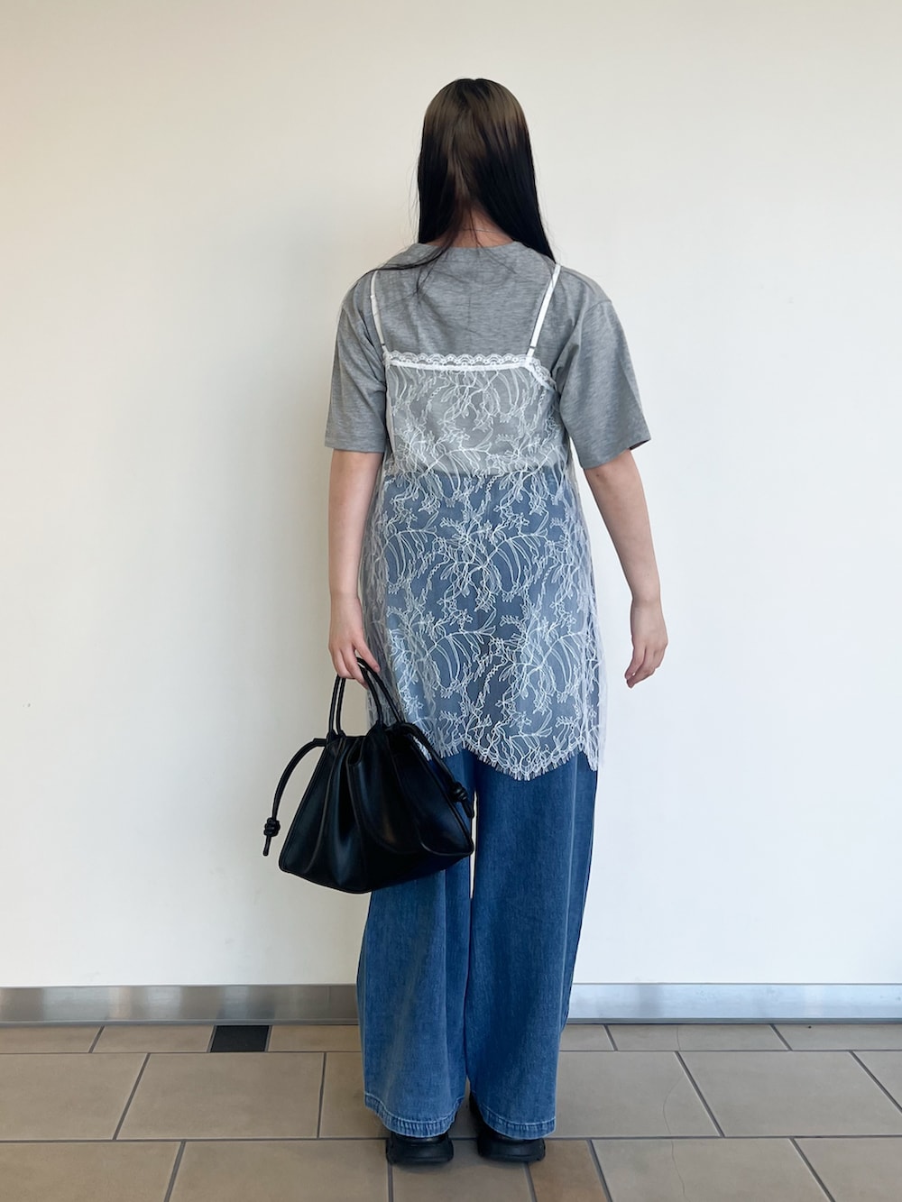 グレー系のTシャツ/カットソー、ホワイト系のキャミソール、ブルー系のデニムパンツを着用したレディースの夏コーディネートの3枚目の写真