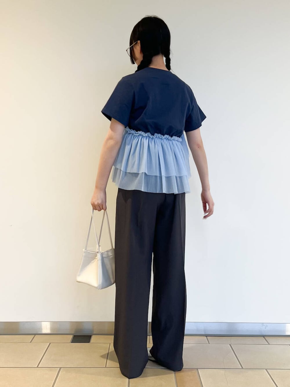 ホワイト系のハンドバッグ、ブルー系のTシャツ/カットソー、グレー系のその他パンツを着用したレディースの夏コーディネートの3枚目の写真