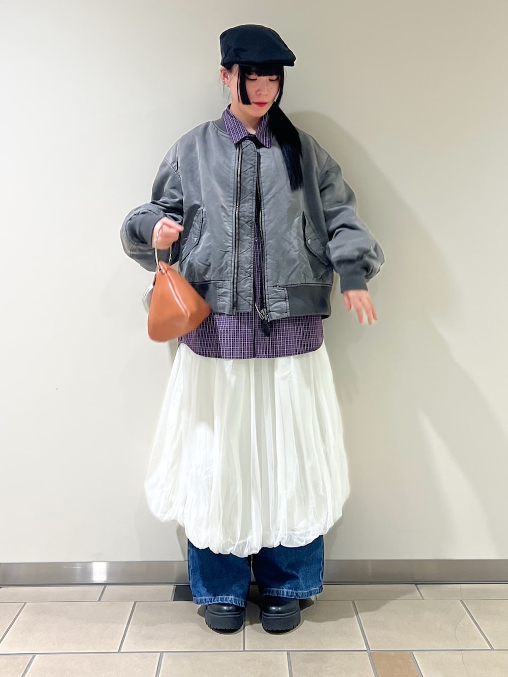 ホワイト系のスカート、パープル系のシャツ/ブラウス、イエロー系のハンドバッグを着用したレディースの冬コーディネートの2枚目の写真