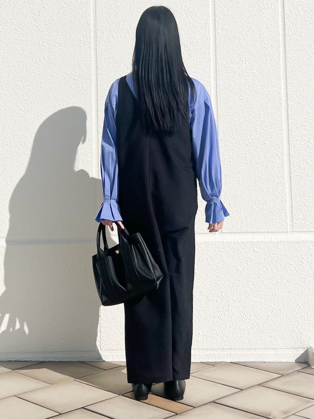 ブラック系のトートバッグ、ブラック系のワンピース、ブルー系のシャツ/ブラウスを着用したレディースの冬コーディネートの2枚目の写真