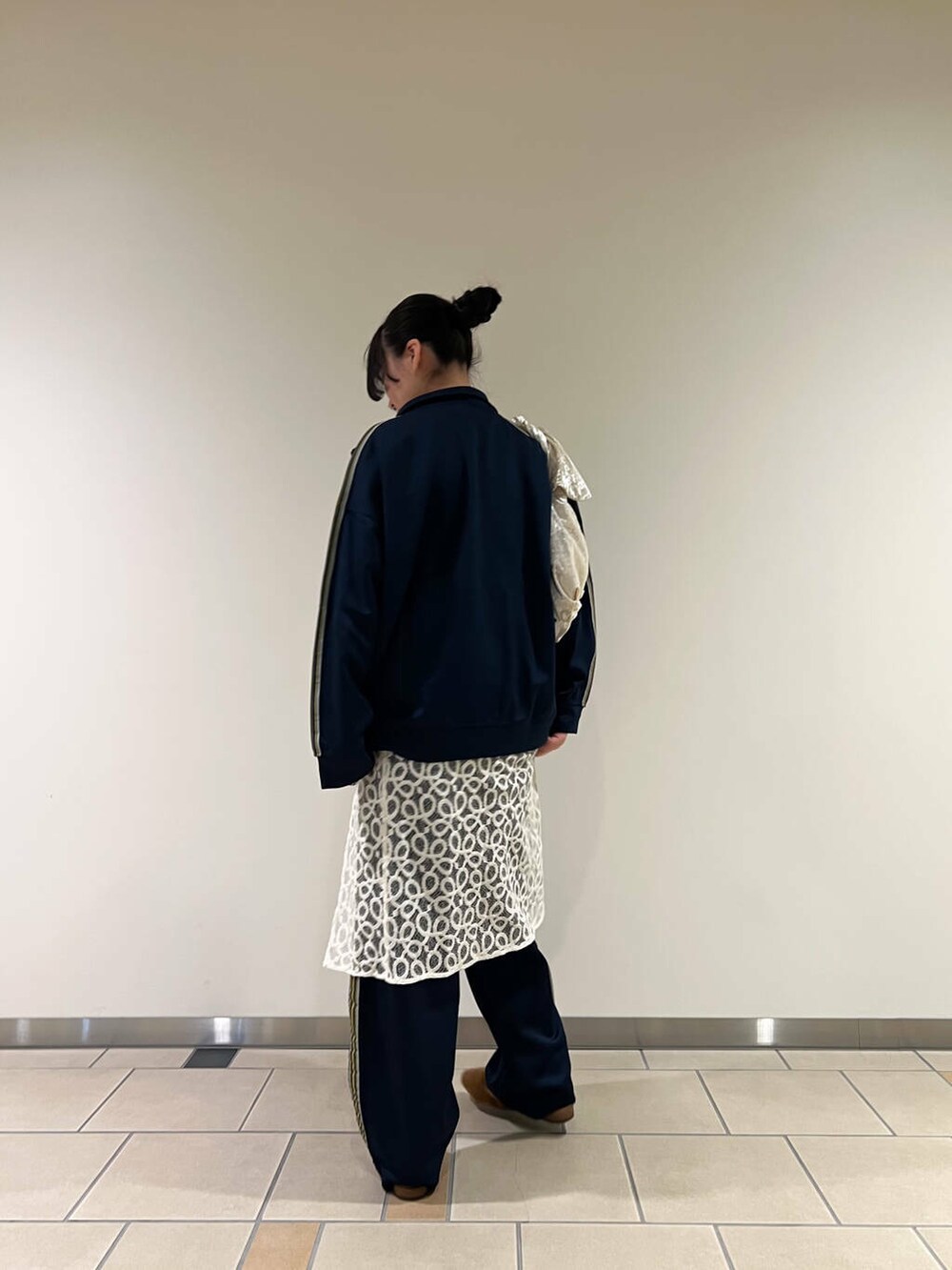 ブルー系のその他パンツ、ブルー系のその他アウター、ベージュ系のハンドバッグを着用したレディースの冬コーディネートの2枚目の写真