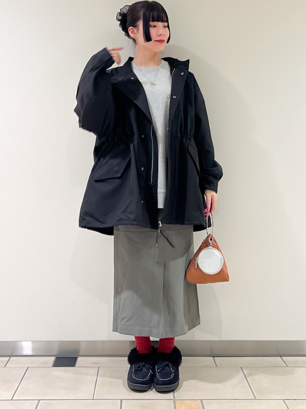 グレー系のスウェット、ブラック系のモッズコート、グリーン系のスカートを着用したレディースの冬コーディネートの3枚目の写真