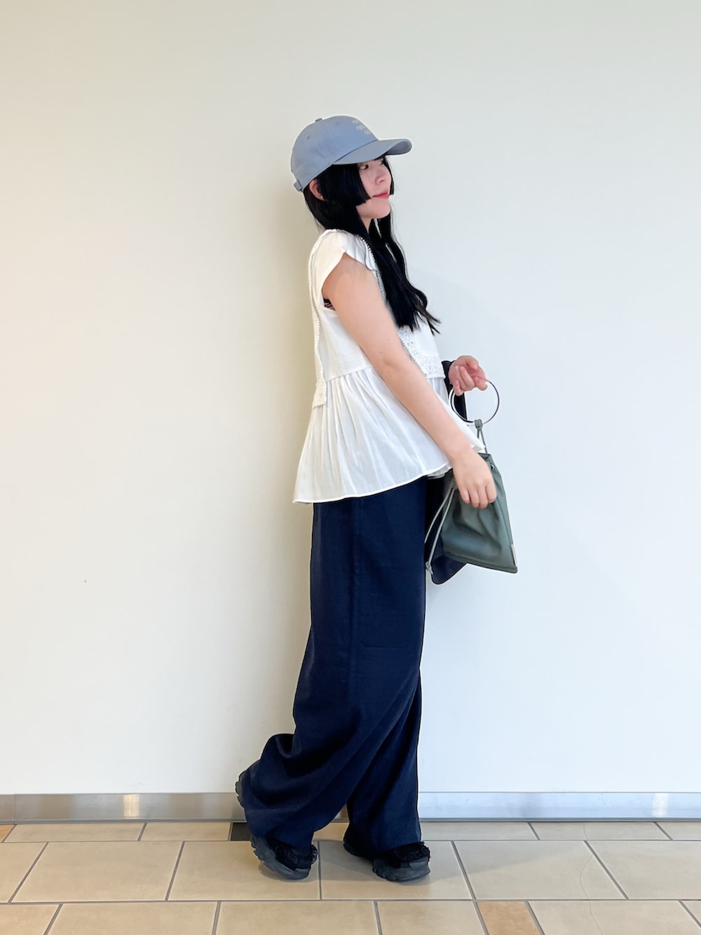 ホワイト系のTシャツ/カットソー、グレー系のダウンベスト、ブルー系のその他パンツを着用したレディースの春コーディネートの3枚目の写真