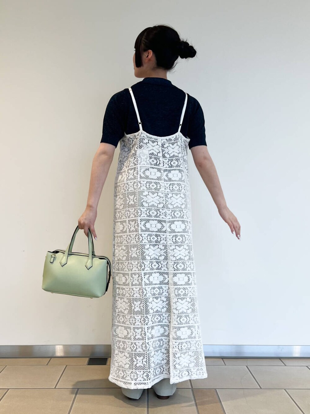 グリーン系のトートバッグ、ブルー系のニット/セーター、ホワイト系のワンピースを着用したレディースの夏コーディネートの2枚目の写真