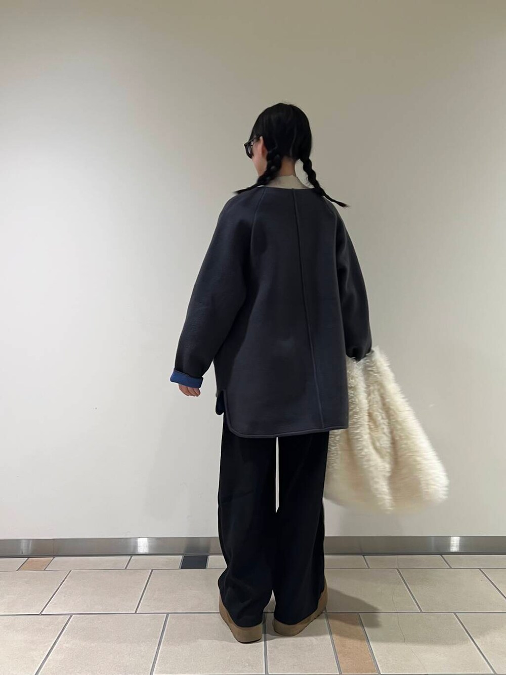 ホワイト系のトートバッグ、グレー系のワンピース、ホワイト系のニット/セーターを着用したレディースの冬コーディネートの3枚目の写真