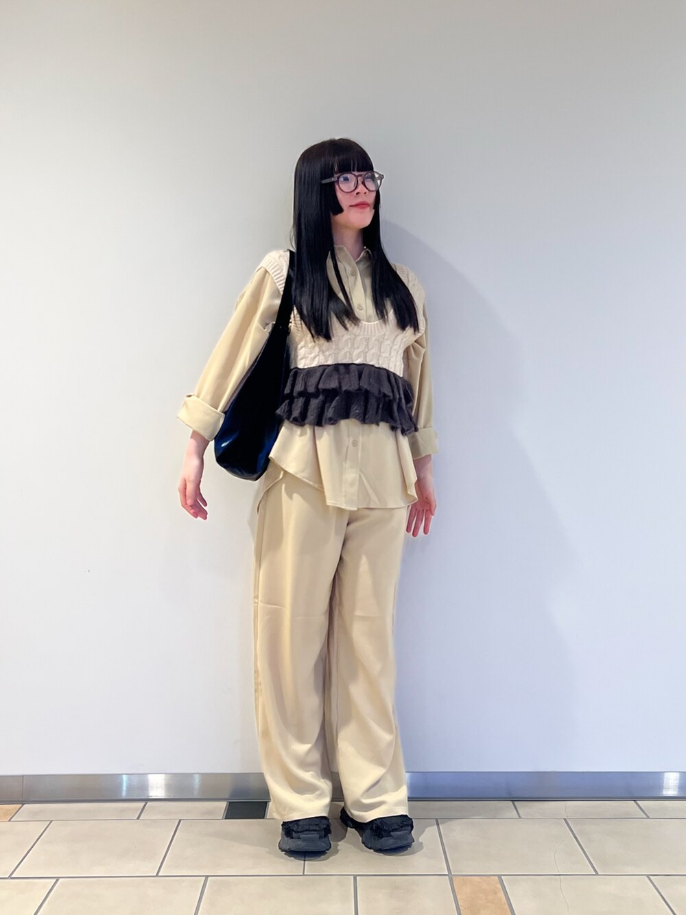 ベージュ系のニット/セーター、ベージュ系のセットアップ、グレー系のメガネを着用したレディースの春コーディネートの2枚目の写真