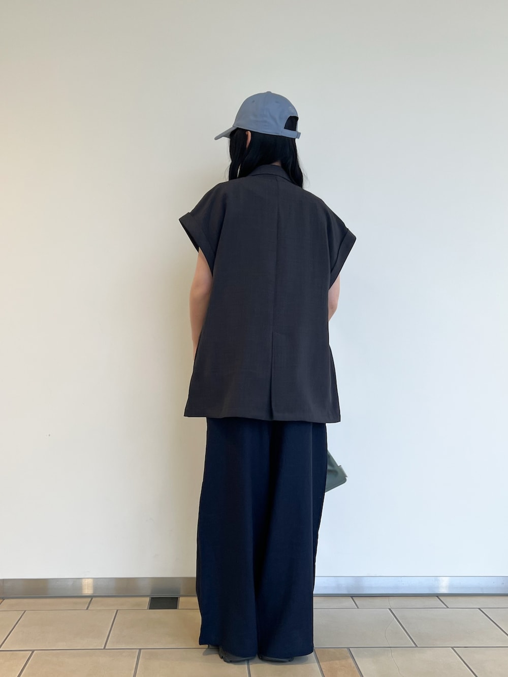 ホワイト系のTシャツ/カットソー、グレー系のダウンベスト、ブルー系のその他パンツを着用したレディースの春コーディネートの6枚目の写真