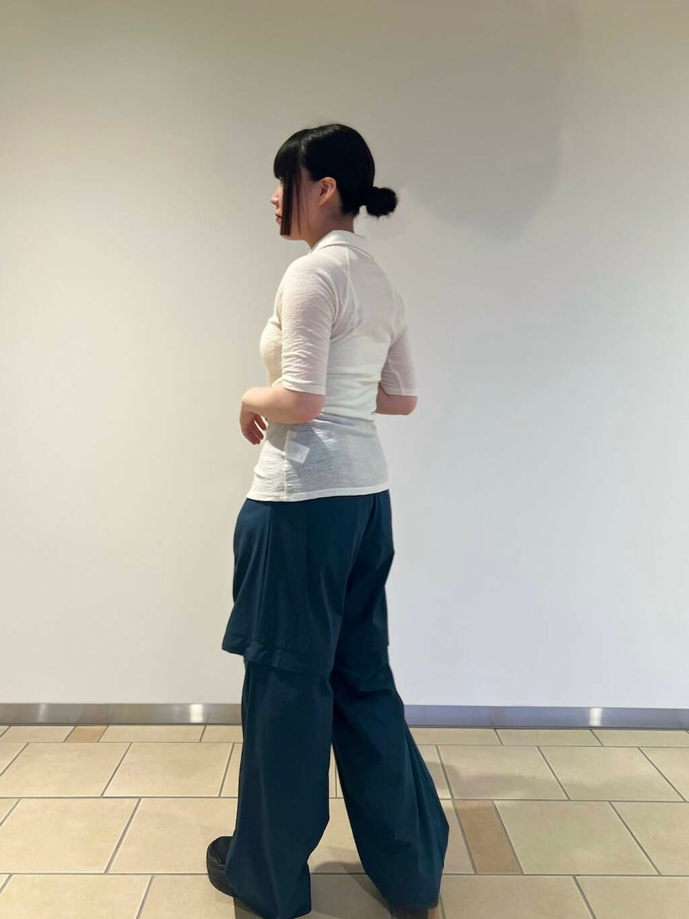 オレンジ系のハンドバッグ、グリーン系のその他パンツ、ホワイト系のカーディガン/ボレロを着用したレディースの秋コーディネートの2枚目の写真