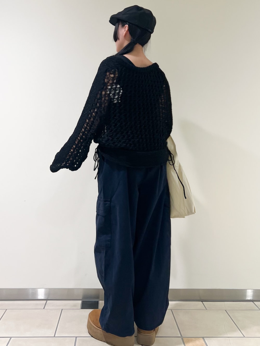 ブラック系のニット/セーター、ブラック系のタンクトップ、ブルー系のその他パンツを着用したレディースの春コーディネートの2枚目の写真