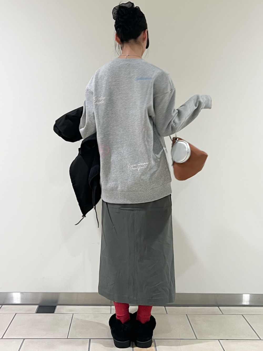 グレー系のスウェット、ブラック系のモッズコート、グリーン系のスカートを着用したレディースの冬コーディネートの2枚目の写真