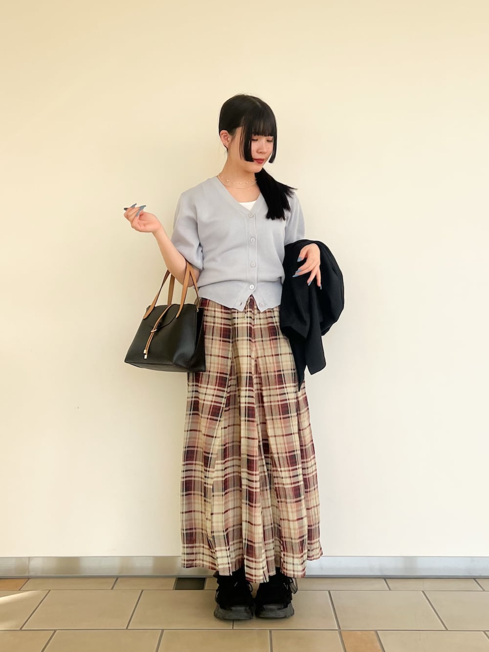 ホワイト系のタンクトップ、シルバー系のカーディガン/ボレロ、ブラック系のその他アウターを着用したレディースの春コーディネートの2枚目の写真