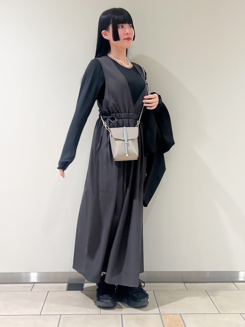 ブラック系のその他アウター、グレー系のワンピース、ブルー系のショルダーバッグを着用したレディースの春コーディネートの2枚目の写真