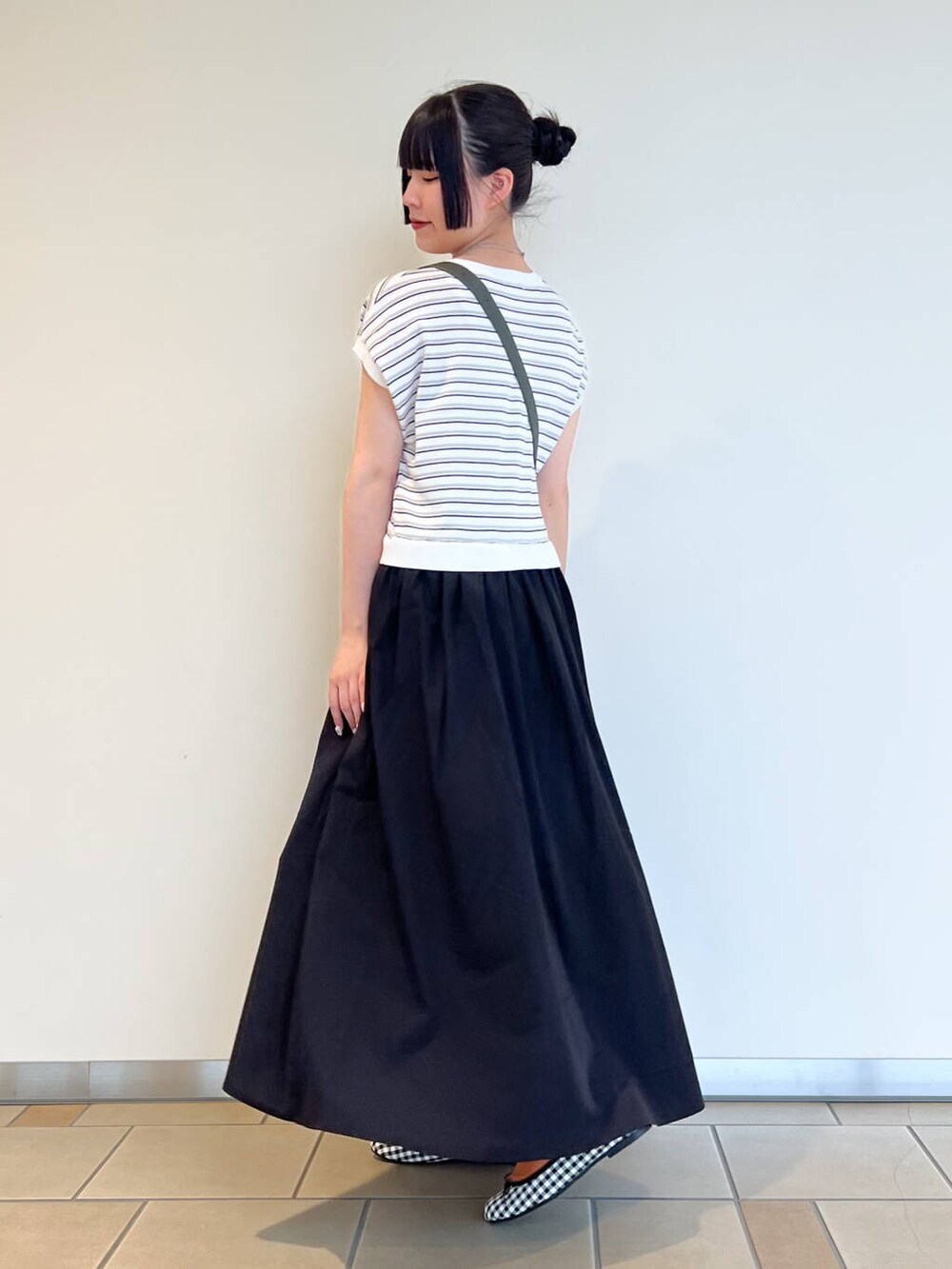 ブラック系のバレエシューズ、グリーン系のショルダーバッグ、ブラック系のワンピースを着用したレディースの夏コーディネートの3枚目の写真