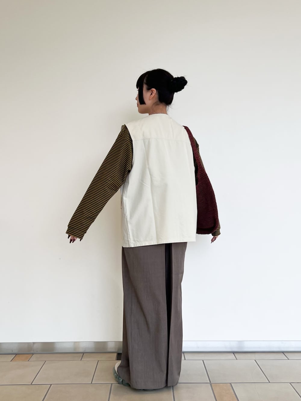 ブラウン系のTシャツ/カットソー、ホワイト系のベスト、ブラウン系のその他パンツを着用したレディースの春コーディネートの3枚目の写真