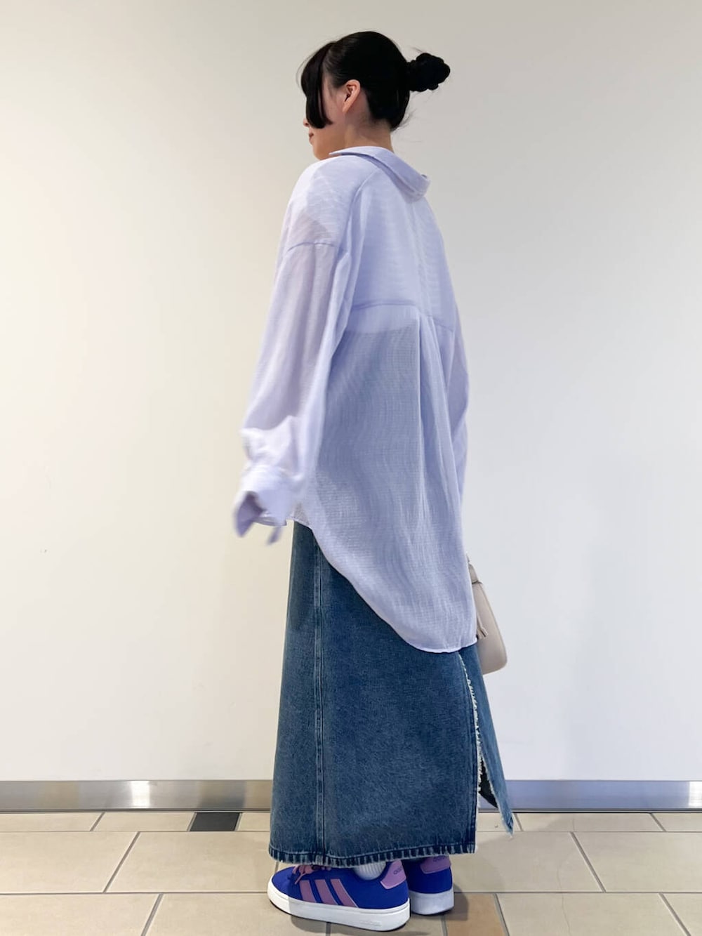 パープル系のシャツ/ブラウス、ホワイト系のTシャツ/カットソー、ブルー系のスカートを着用したレディースの春コーディネートの2枚目の写真