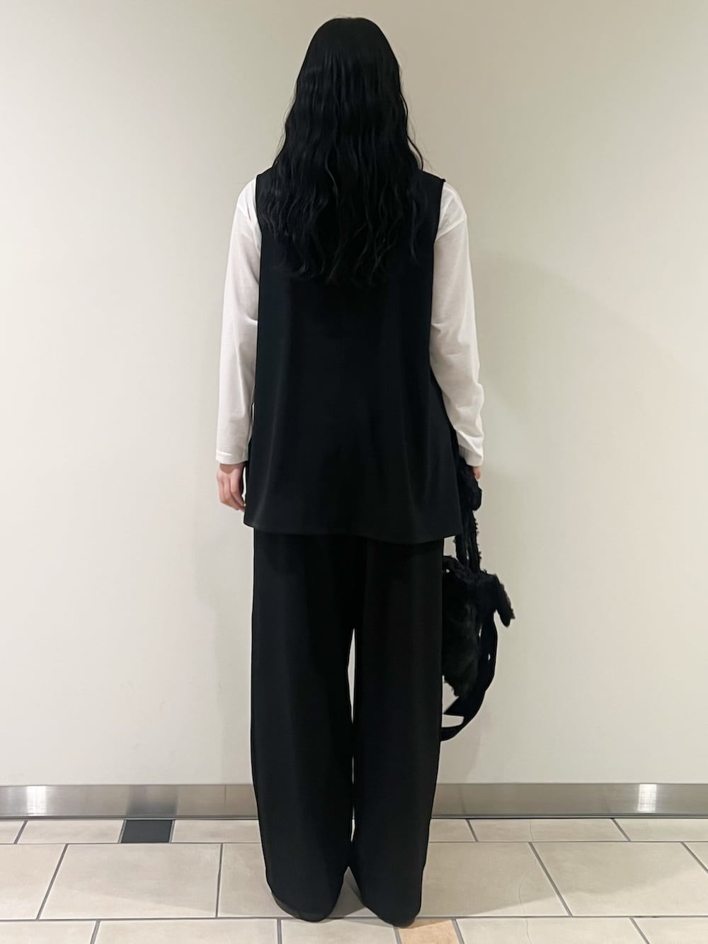 ブラック系のセットアップ、ブラック系のローファー、ブラック系のネックレスを着用したレディースの春コーディネートの3枚目の写真