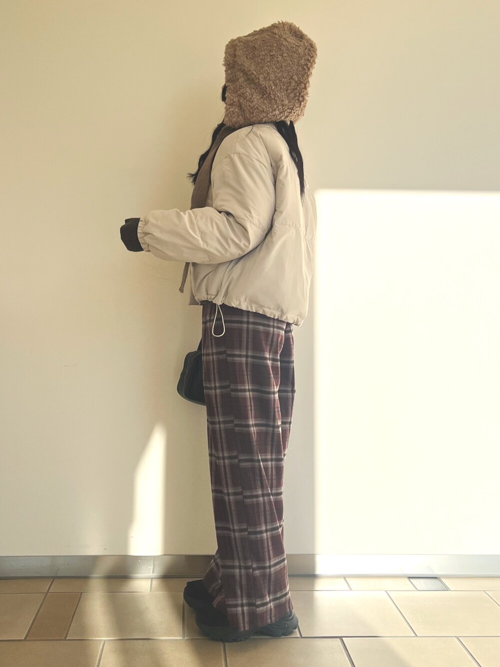 グレー系のダウンジャケット/コート、ブラウン系のニット/セーター、レッド系のその他パンツを着用したレディースの冬コーディネートの3枚目の写真