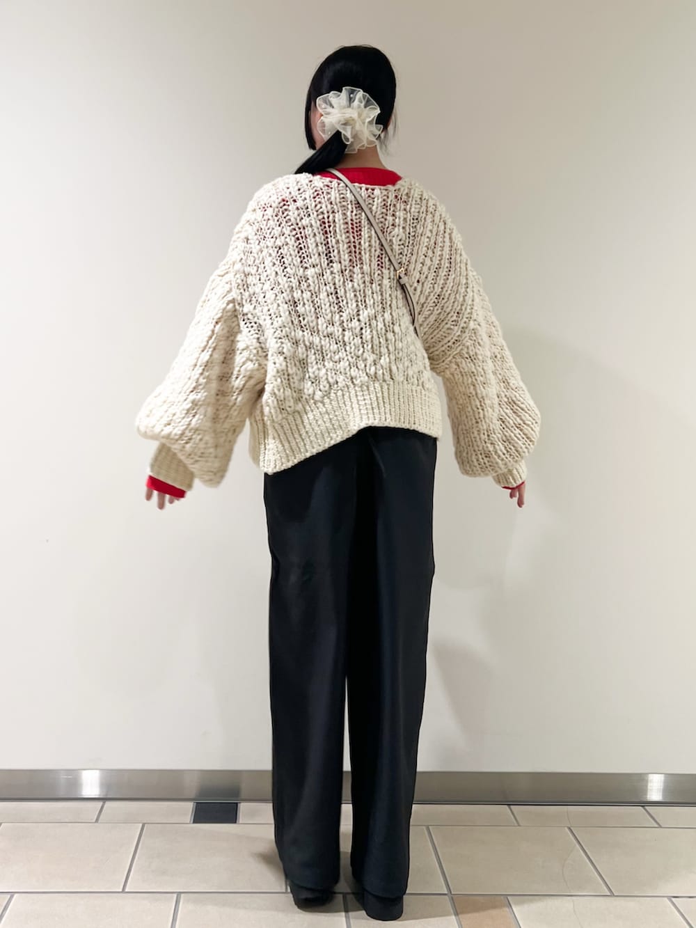 ホワイト系のカーディガン/ボレロ、レッド系のニット/セーター、グレー系のサロペット/オーバーオールを着用したレディースの冬コーディネートの3枚目の写真