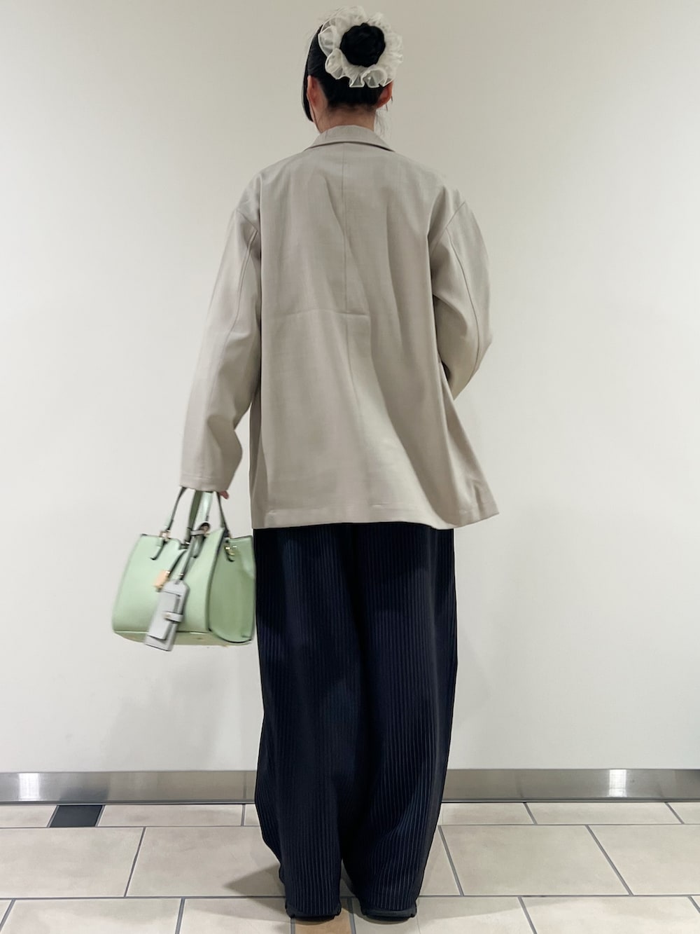 その他のその他パンツ、グリーン系のハンドバッグ、ベージュ系のその他アウターを着用したレディースの春コーディネートの3枚目の写真