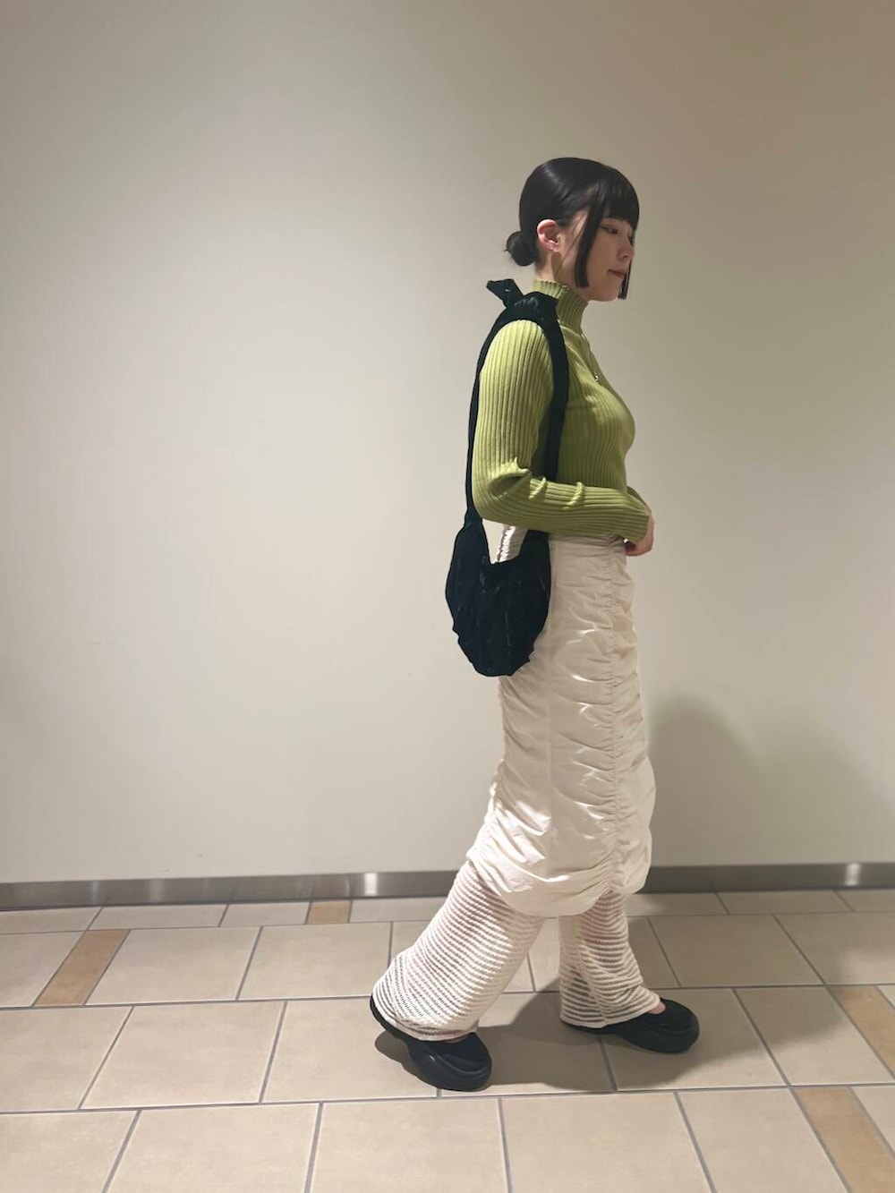 グリーン系のニット/セーター、ホワイト系のその他パンツ、ブラック系のハンドバッグを着用したレディースの秋コーディネートの3枚目の写真