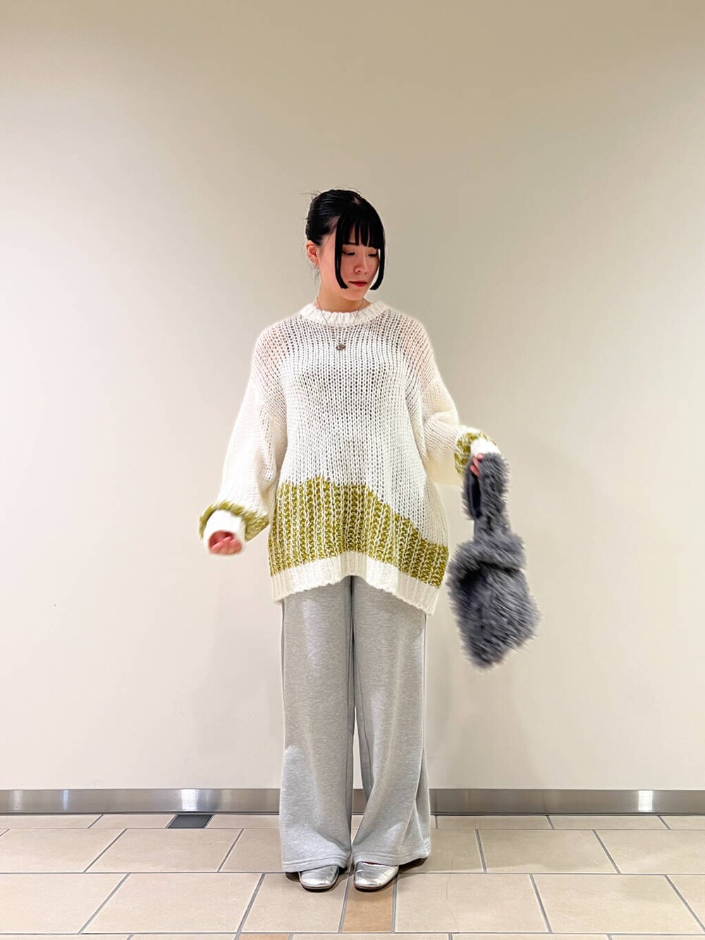 ホワイト系のニット/セーター、ベージュ系のタンクトップ、グレー系のその他パンツを着用したレディースの秋コーディネートの3枚目の写真