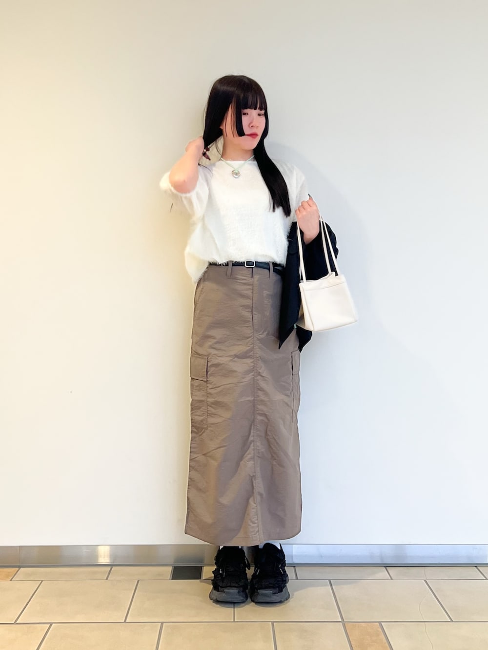 ホワイト系のシャツ/ブラウス、ブラウン系のスカート、ホワイト系のハンドバッグを着用したレディースの春コーディネートの2枚目の写真
