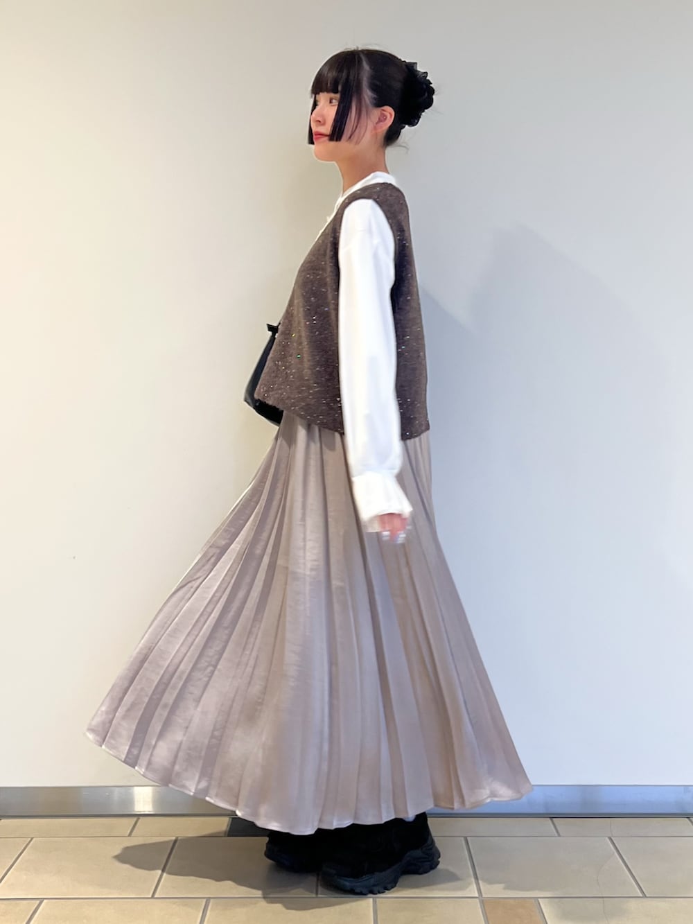 ホワイト系のシャツ/ブラウス、ベージュ系のスカート、ブラウン系のニット/セーターを着用したレディースの秋コーディネートの2枚目の写真