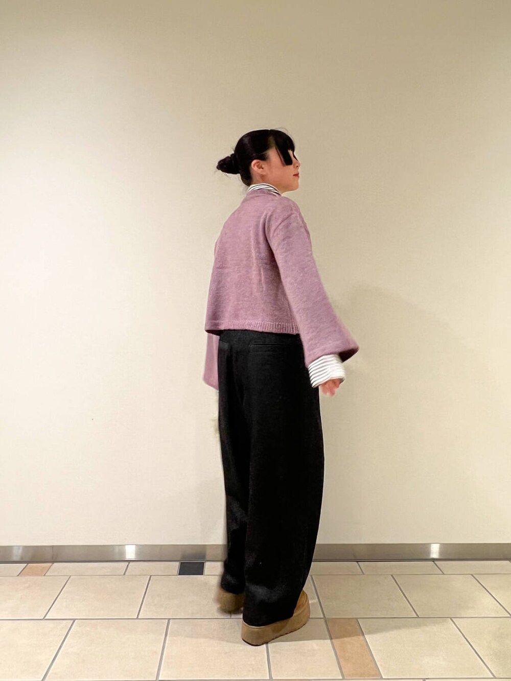 グリーン系のハンドバッグ、ブラック系のデニムパンツ、ホワイト系のTシャツ/カットソーを着用したレディースの冬コーディネートの3枚目の写真