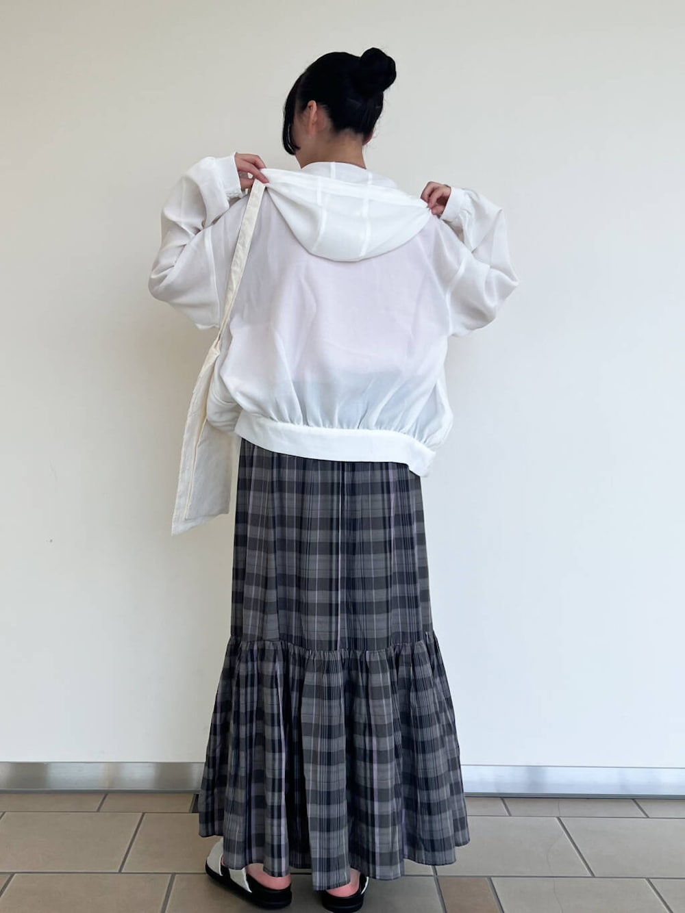 グレー系のサンダル、ホワイト系のマウンテンパーカー、ホワイト系のトートバッグを着用したレディースの夏コーディネートの3枚目の写真