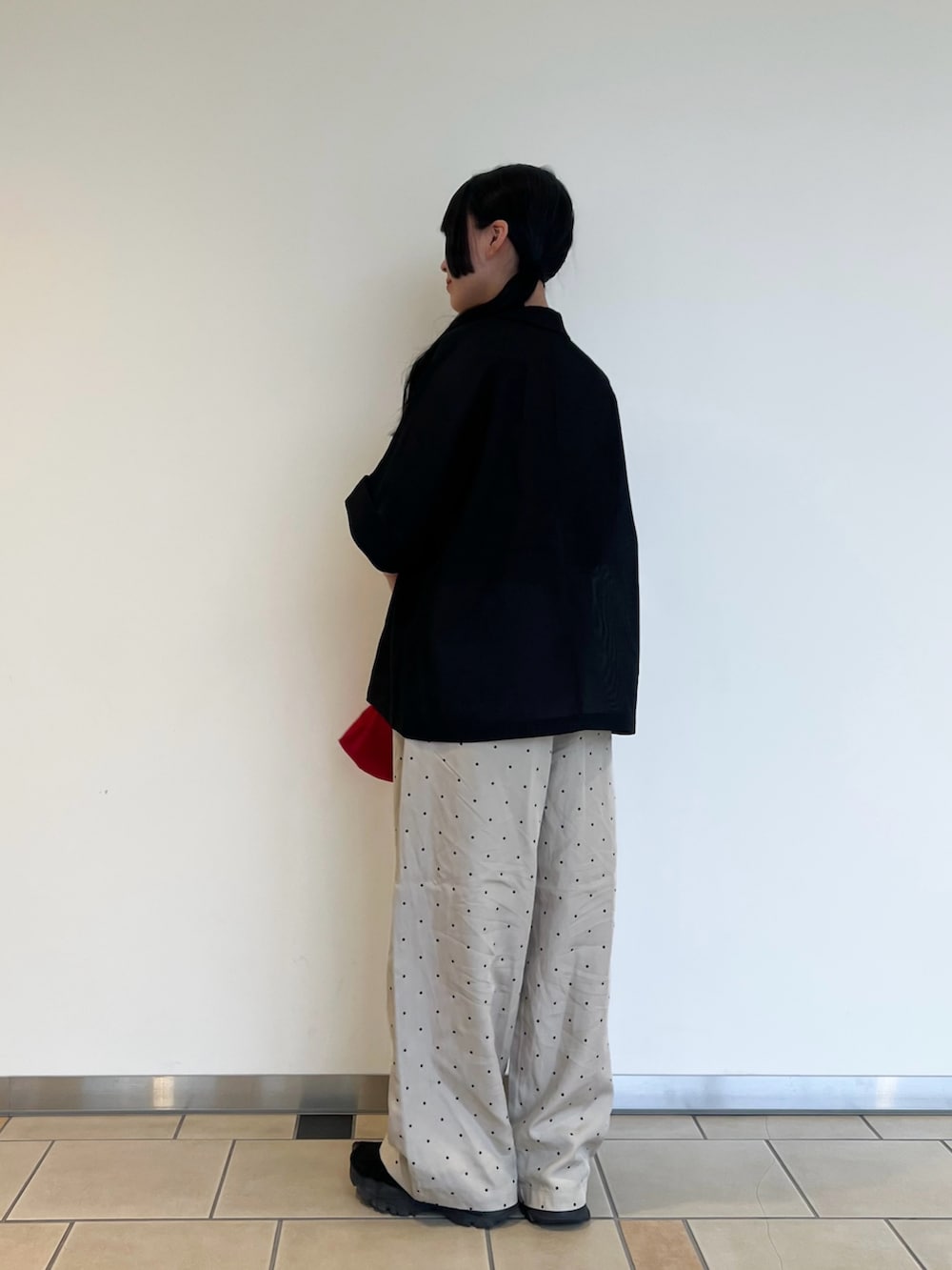 ブラック系のタンクトップ、ブラック系のその他アウター、レッド系のエコバッグ/サブバッグを着用したレディースの夏コーディネートの3枚目の写真